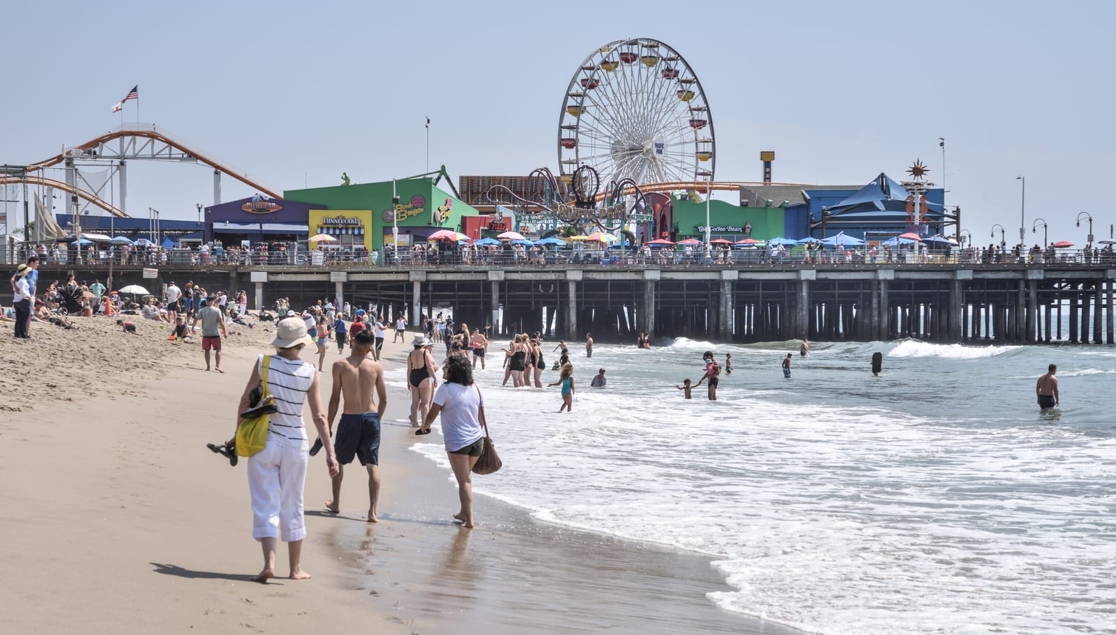 The Santa Monica Pier with the Pacific Park Ferris wheel above the beach in Santa Monica, California